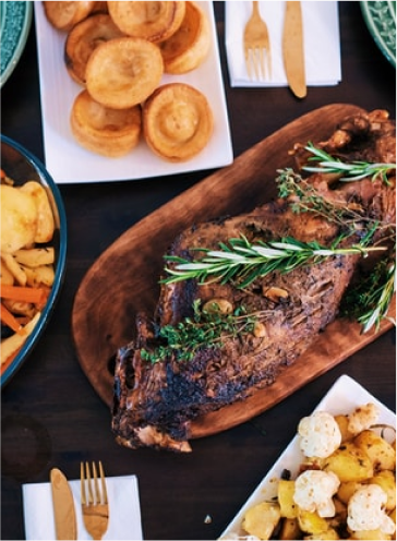 A delicious platter of food centered around a roasted duck. 